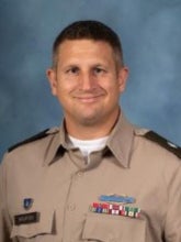 A white man with brown hair wearing a tan Army uniform