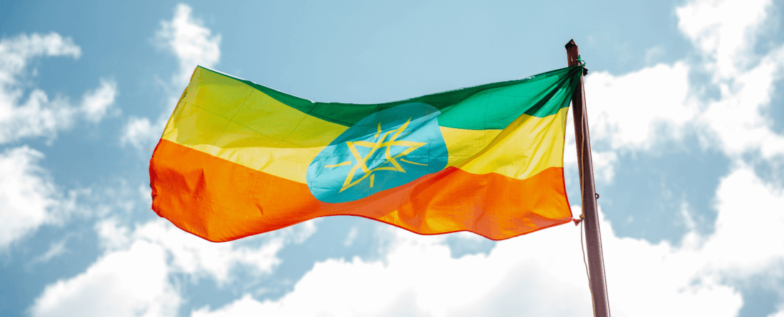 Ethiopian Flag under a partly cloudy sky